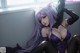 A woman with long purple hair sitting on a window sill.