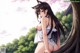 Anime girl with long black hair sitting on a tree.