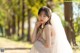 A woman in a wedding dress sitting on a dirt road.