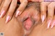 A close up of a woman's pussy with pink fingernails.