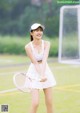 A woman holding a tennis racquet on a tennis court.