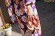 A woman wearing a purple and orange kimono and flip flops.