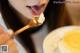 A woman eating a piece of cake with a spoon.